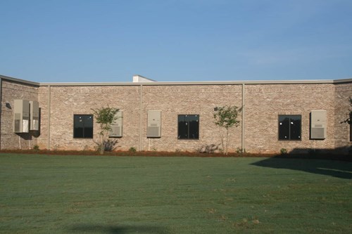 Multiple Bard exterior wall-mount air conditioners used to cool individual classrooms as part of a decentralized system.