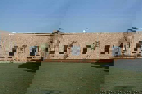 Mulitple Bard exterior wall-mount air conditioners installed on a school following an HVAC retrofit.